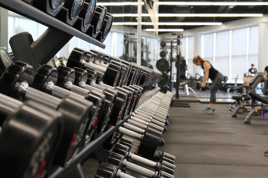 Rows of dumbbells on a rack inside a modern strength gym